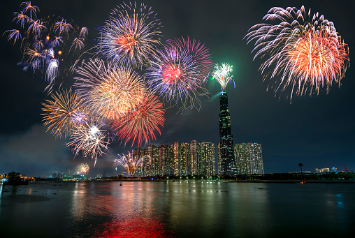 Colorful fireworks happy new year 2021 light up sky over business district in Ho Chi Minh city view from Landmark 81 riverside. Landmark 81 is the tallest building in Vietnam