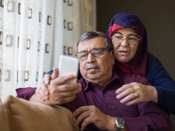 istock Senior couple using smartphone, having video call at home 1295415332