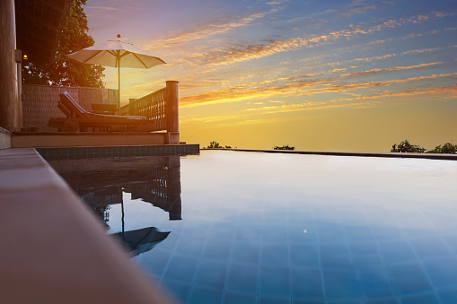 Exotic romantic sunset beatiful pool villa resort. Infinity pool with amazing sunset sky. Pool villa with beautiful romantic view.