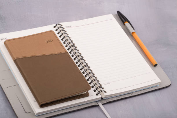 istock 2021 schedule book and pen on gray background. 1295419159