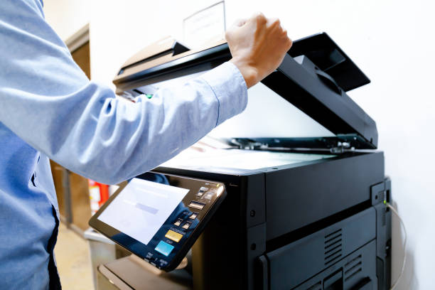 istock Bussiness man Hand press button on panel of printer, printer scanner laser in office. 1295420219