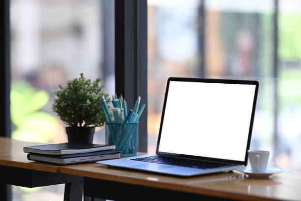 istock Simple workspace with laptop computer mock up, office supplies and plant decoration on desk. 1295420974
