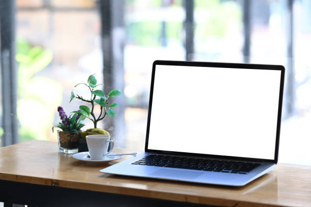 istock Mock up laptop computer with blank white screen on wooden desk. Blank screen for graphic display montage. 1295421810