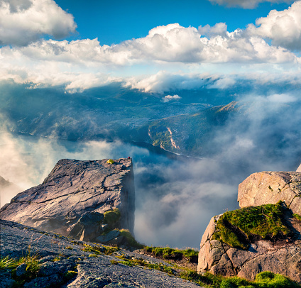 Misty morning view of popular Norwegian attraction Preikestolen. Great summer scene of the Lysefjorden fjord, located in the Ryfylke area in southwestern Norway. Beauty of nature concept background.