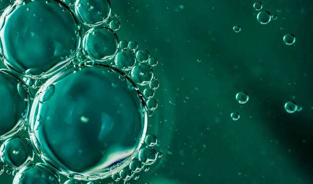 istock oil drops on water on blue background 1295429670