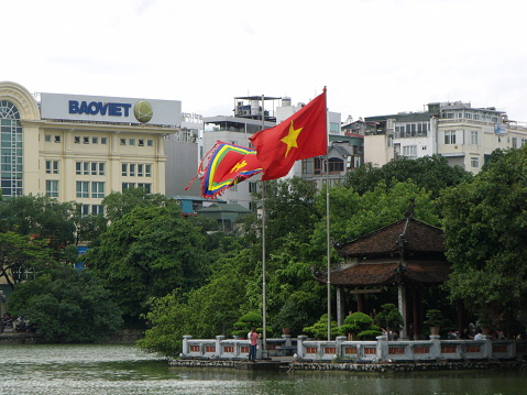 Hanoi, Vietnam, June 16, 2016: Flags on the shore of Hoan Kiem Lake in Hanoi