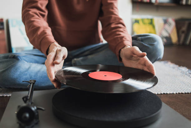 Man listening music, relaxing, enjoying life at home party. Turntable playing vinyl LP record Young man having fun at home. Enjoy life, have fun, lifestyle, leisure, music, hobby, lockdown, technology, winter concept retro turntable stock pictures, royalty-free photos & images