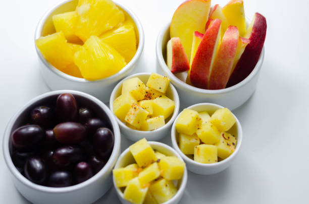 istock Various set fruits, pineapple, apple, grapes with matured cheddar cheese in bowls 1295441792