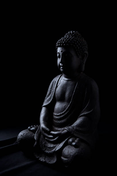 istock Meditating Buddha Statue isolated on black background. Copy space. 1295442545