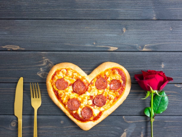 istock Heart shaped pizza for valentines day with rose, copy space. 1295443810