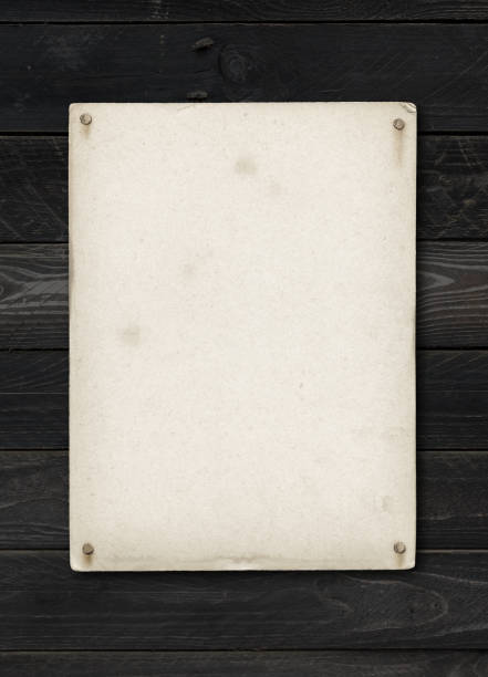 istock Old textured paper sheet nailed on a black wood table 1295449400