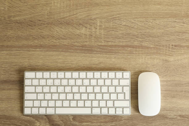 istock Keyboard and mouse on wooden background, top view 1295451802
