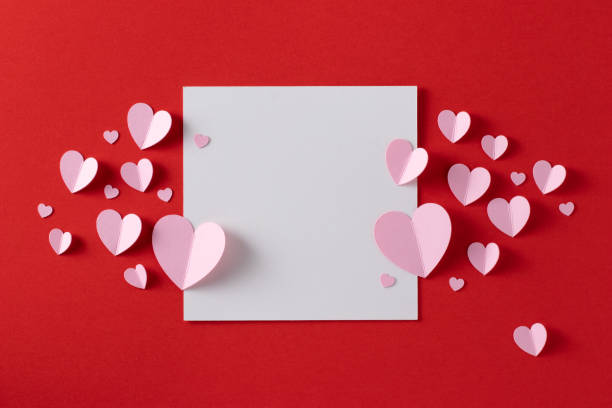 istock Pink paper hearts with blank white note for Valentine’s Day message. 1295451887