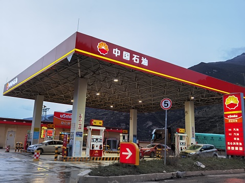 Auto repair shop of Ptt gasoline station in Bangkok Ladprao. Inside are car of customer and some staffs. Scene is at gasoline station at Wanghin Road