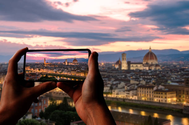 Tourist taking photo of Florence at sunset from Piazzale Michelangelo, Florence, Italy. Beautiful panoramic view of Duomo Santa Maria Del Fiore and tower of Palazzo Vecchio during evening. Tourist taking photo of Florence at sunset from Piazzale Michelangelo, Florence, Italy. Beautiful panoramic view of Duomo Santa Maria Del Fiore and tower of Palazzo Vecchio during evening. photo messaging photos stock pictures, royalty-free photos & images