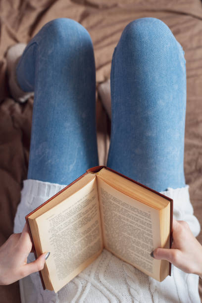 istock Young girl on bed with a book. 1295457290