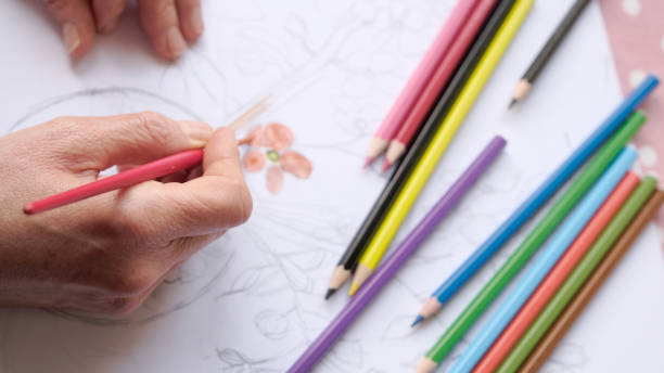 istock Female hands painting a flower. 1295457788