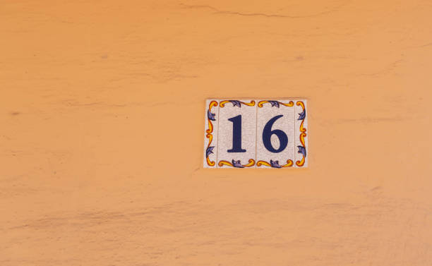 istock Decorative ceramic house number 16 tile on the wall, characteristic decorative element 1295458703