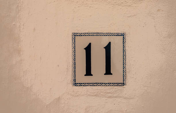 Decorative ceramic house number 11 tile on the wall, characteristic decorative element