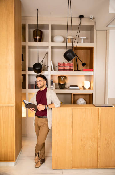 istock Handsome young man in casual clothes and with eyeglasses reading a book 1295458964