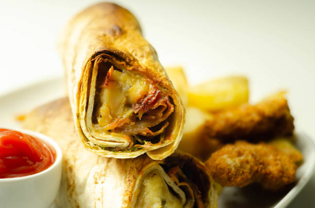 istock Tortilla wrap with chicken and beechwood smoked bacon served with chicken nuggets and chips on the white plate 1295460042