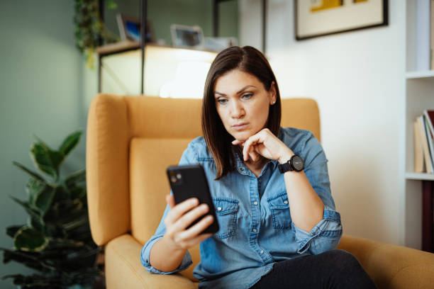 istock Confused woman at home using smart phone for work during covid-19 quarantine 1295462010
