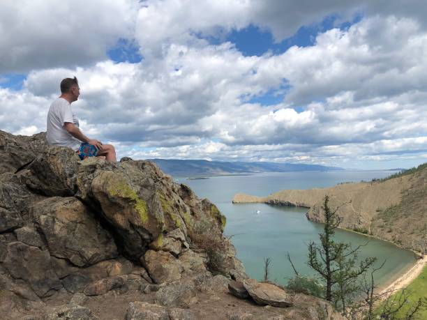 istock Man sits on a mountain top. Success concept 1295468868