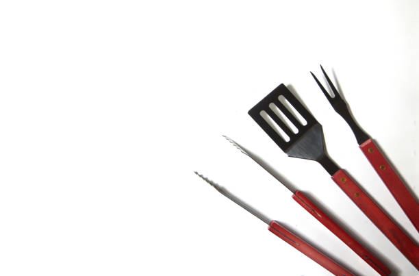 istock BBQ instruments kit - tongs, spatula, fork - close up isolated on white background flat lay 1295474865