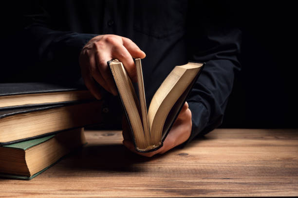 istock Man illuminates the darkness by reading a book 1295477684
