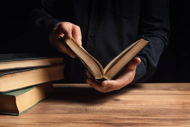 istock Man illuminates the darkness by reading a book 1295477778