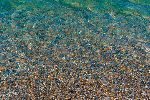 multicolored sea pebbles under water.