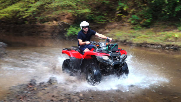 istock Hispanic man driving an off-road vehicle panning motion 1295480347