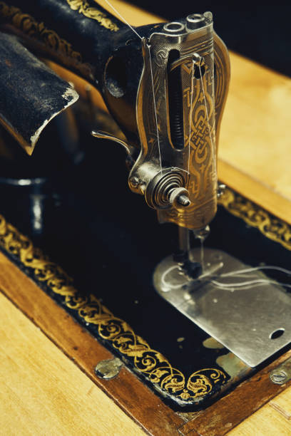 istock Vintage manual sewing machine at wooden table closeup 1295482357