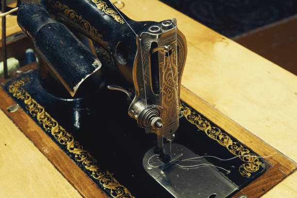 istock Vintage manual sewing machine at wooden table closeup 1295482358