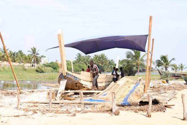 construtor de navios na praia de aneho, togo, conserte um barco tradicional. - vela peça de embarcação - fotografias e filmes do acervo