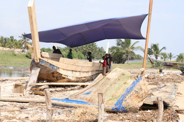 construtor de navios na praia de aneho, togo, conserte um barco tradicional. - vela peça de embarcação - fotografias e filmes do acervo