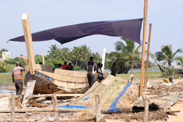 construtor de navios na praia de aneho, togo, conserte um barco tradicional. - vela peça de embarcação - fotografias e filmes do acervo