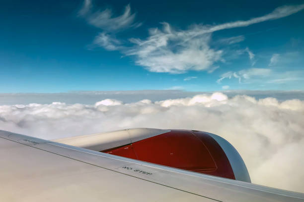 En route London - Seattle - June 2018: White clouds and blue sky over the wing and engine of a Virgin Atlantic aircraft.