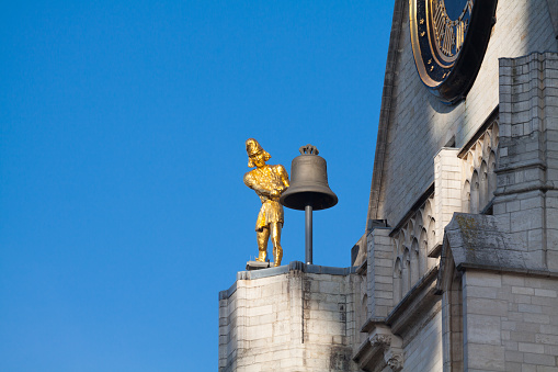 Golden bell ringer statue of church St Peter in Leuven