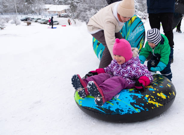 uma família de caucasianos em férias de fim de semana de inverno. uma jovem com filhos, uma menina de 5 anos e um menino de 3 anos. divirta-se e prepare-se para descer a montanha nevada. - 2 3 years children only group of people enjoyment - fotografias e filmes do acervo