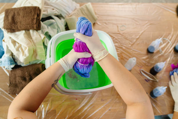 Young woman making tie dye indoors