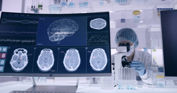 istock Laboratory equipment. Brainwave research on screens. Female scientist working with microscope in background 1295492995