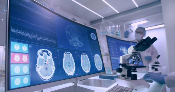 istock Laboratory equipment, microscope and computers. Brainwave research on screens. Rear view of scientists 1295493015