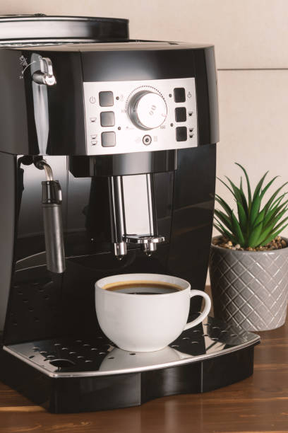 istock Modern espresso coffee machine with a cup in interior of kitchen closeup. 1295494423