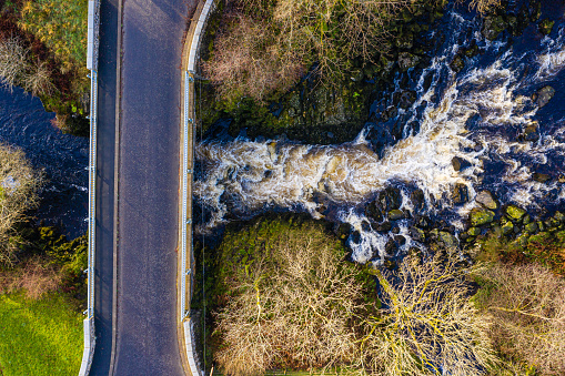 The aerial view from a drone of a river flowing under a bridge in a rural part of Dumfries and Galloway south west Scotland