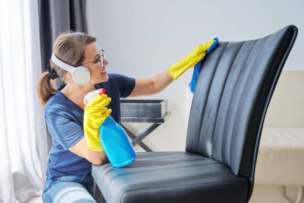 limpieza del hogar en positivo, mujer en auriculares y guantes limpia sillón, muebles - all laundry detergent audio fotografías e imágenes de stock