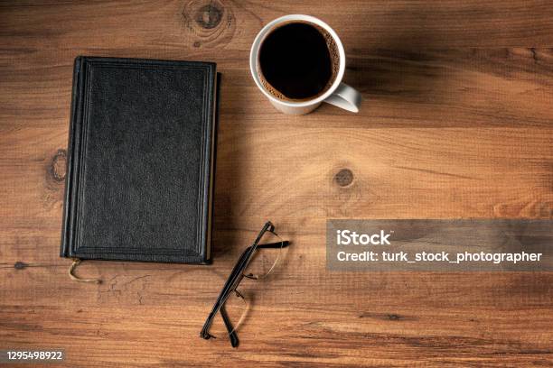 Black Hardcover Old Book Coffee And Glasses On The Table Top View Stock Photo - Download Image Now