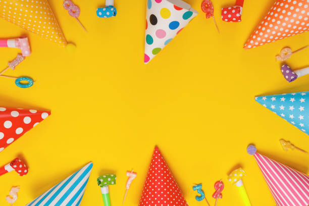 istock Colored party hat and candles lying on yellow background. 1295500965