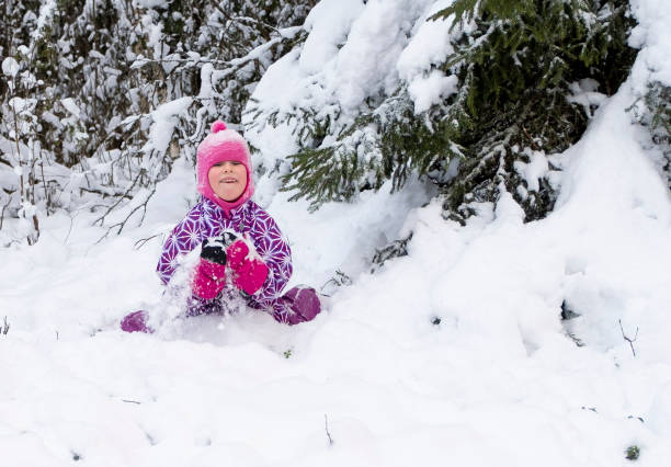 ein kind, ein 5-jähriges kaukasiermädchen, spielt fröhlich im tiefschnee. - child winter snow 4 5 years stock-fotos und bilder