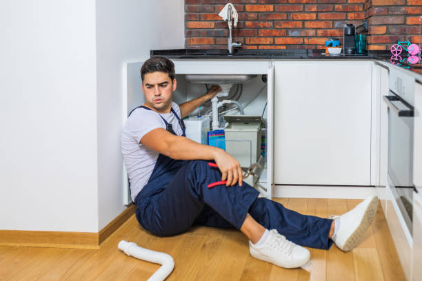 istock Young plumber fixing a sink in the kitchen. 1295502038